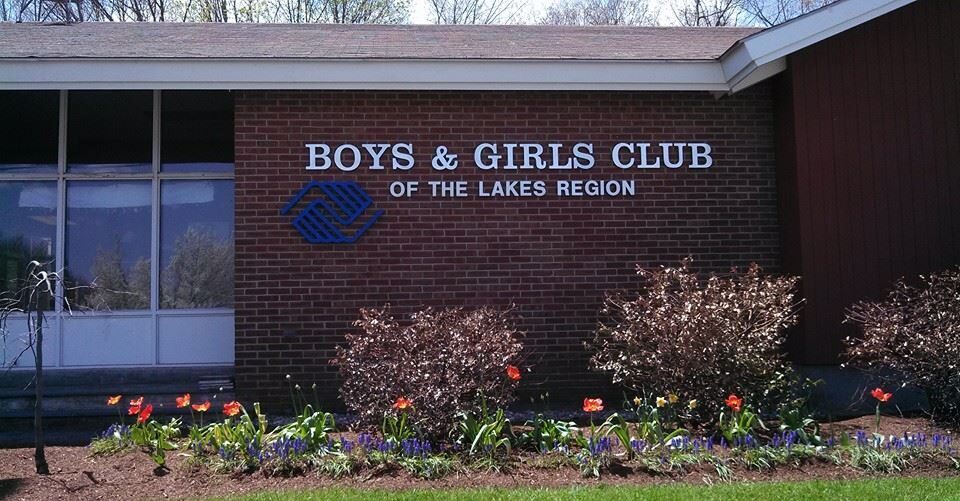 Boys & Girls Clubhouse Lakes Region Brick building with flower bed and the sign "Boys & Girls Club of the Lakes Region"