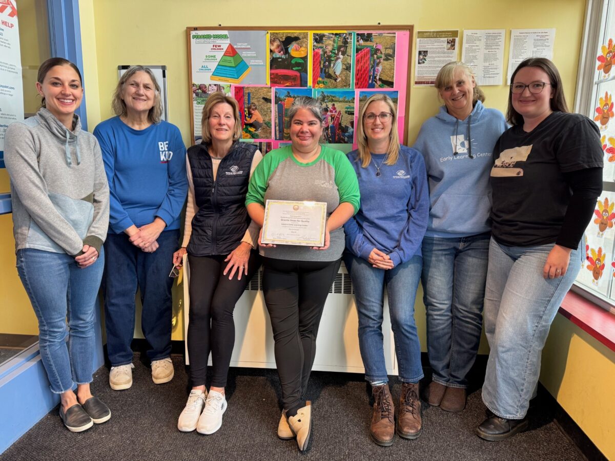 Staff gathered around their new certification for Step 4 Granite Steps to Quality